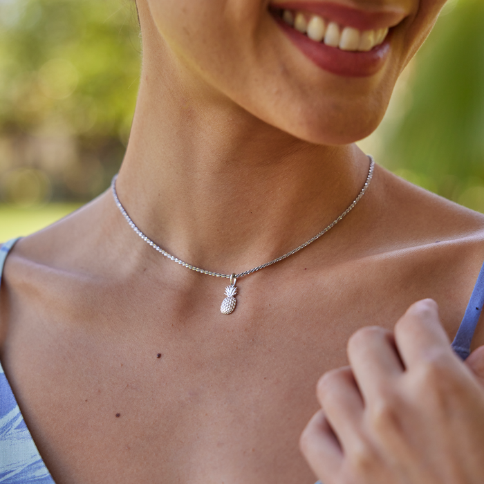Close up of woman outdoors wearing a Pineapple Charm/Pendant in Sterling Silver