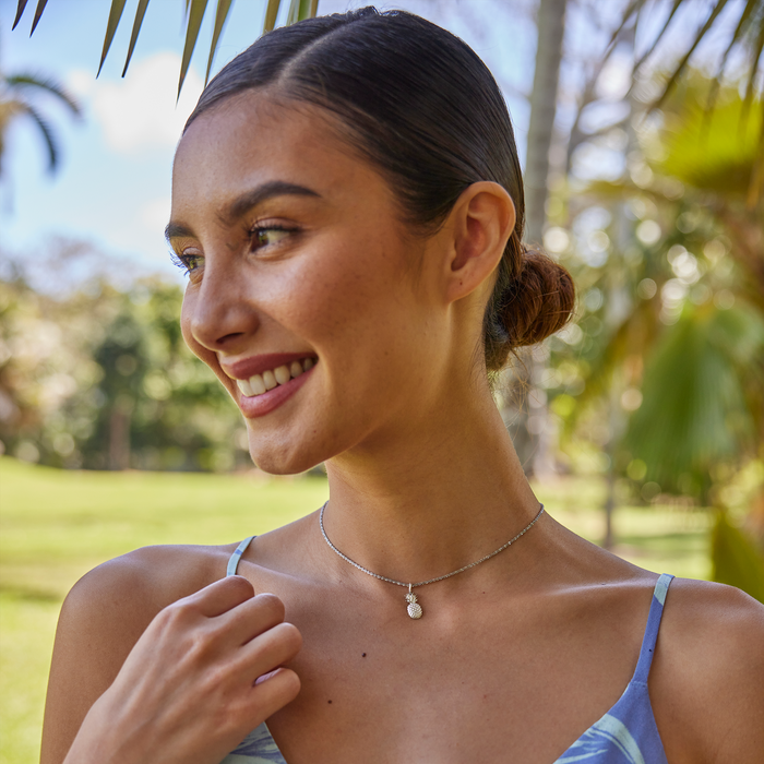 Woman smiling in a park wearing a Pineapple Charm/Pendant in Sterling Silver