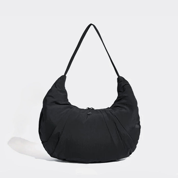 Angled view of Pleated Crescent Shoulder Bag in black, great for everyday carry and travel.