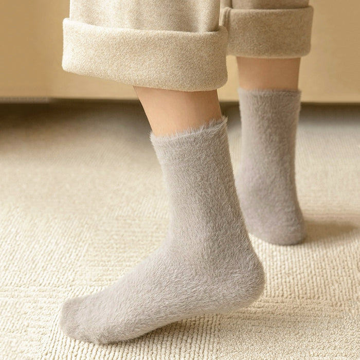 Model wearing a pair of Plush Cozy Socks in gray, easy to pack for travel and errands.