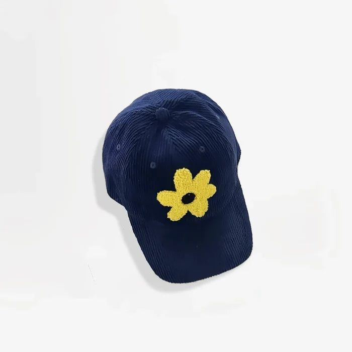 Navy blue corduroy baseball cap featuring a yellow plush flower embroidery.