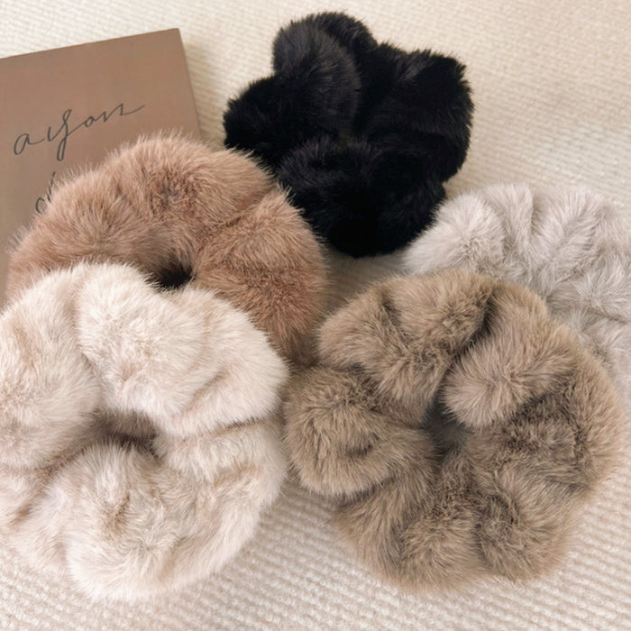Assortment of five plush faux fur scrunchies in black, beige, tan, brown and grey.