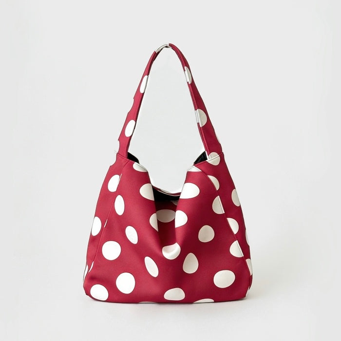 Red suede bag with white polka dots, highlighting the slouchy hobo silhouette.
