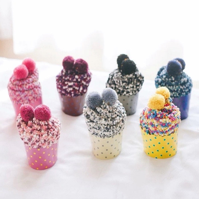Six pairs of colorful polyester pompom cupcake socks in various patterns and gift wrappers.