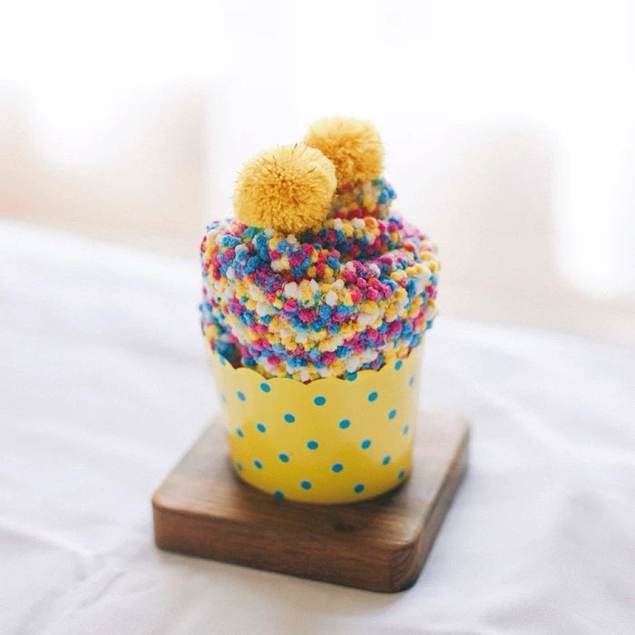 Close-up of Pompom Cupcake Socks in yellow, easy to pack for travel and errands.
