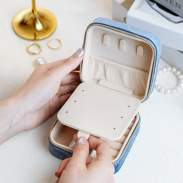 Model holding a portable velvet jewelry case, showing the inteior detail.