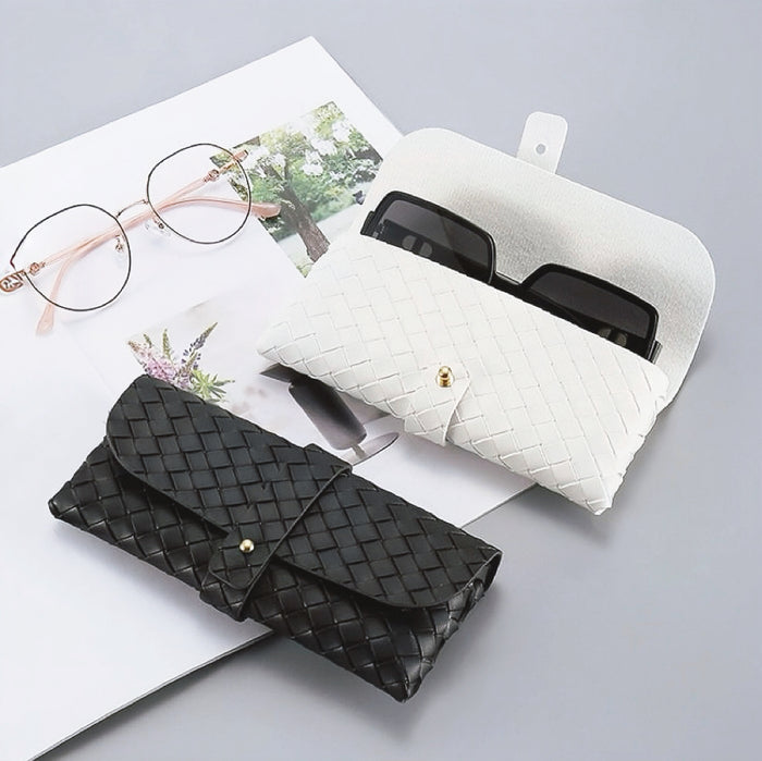 Angled view of two Portable Woven Leather Glasses Case show together, black is close and white is open.