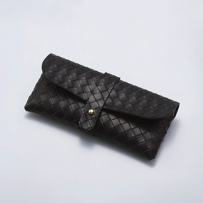 Flat lay of black Portable Woven Leather Glasses Case with buckle closure.