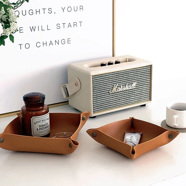 Two brown PU leather trays, one small and one medium, with snap corners, on a white surface storage.