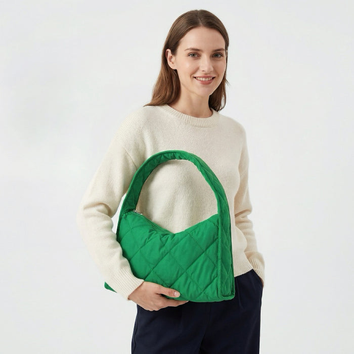 Model wearing a forest green quilted puffy hobo bag for an urban chic look.
