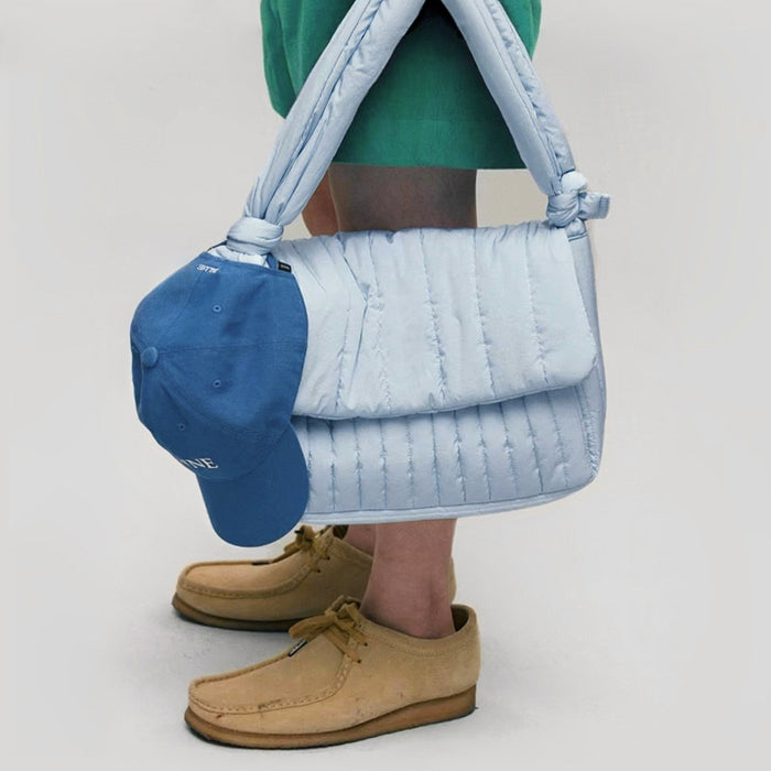 Model carrying a polyester Puffy Knot Quilted Baghandheld , great for daily carry and travel.