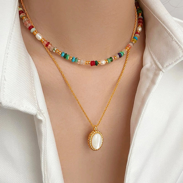 Model wearing two necklaces as layer style, one is colorful beads necklace and one is gold jade.
