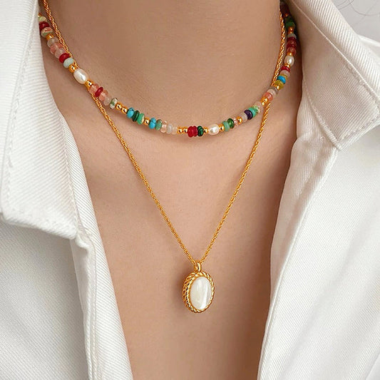 Model wearing two necklaces as layer style, one is colorful beads necklace and one is gold jade.