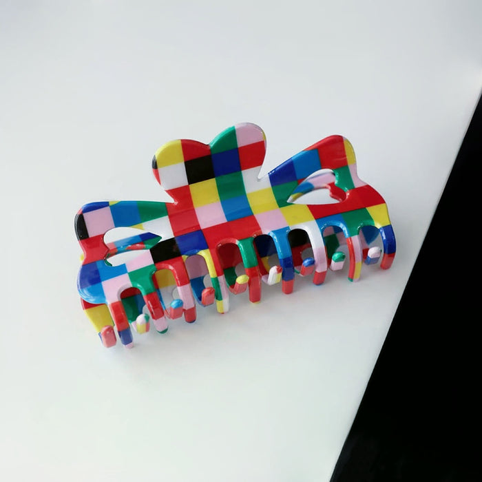 Flat lay of Rainbow Plaid Claw , ideal for quick updos and ponytails.