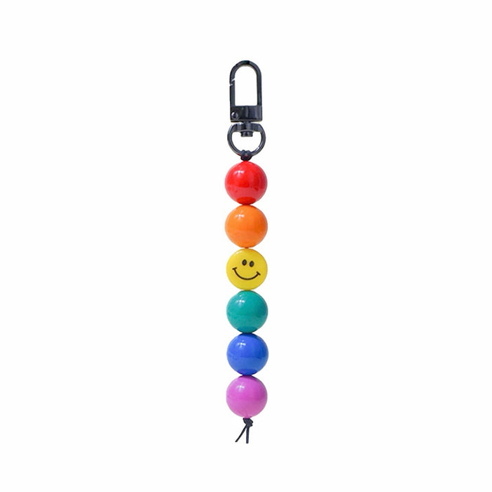 Front view of Rainbow acrylic bead bag charm with a yellow smiley face bead and black clip.