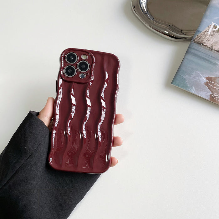 Hand holding the red raised wave silicone phone case.