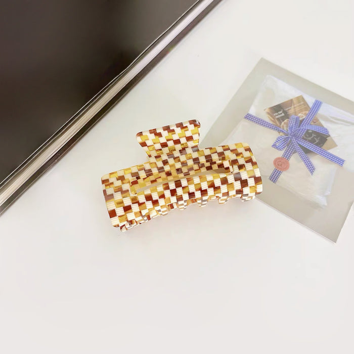 Flat lay of Rectangle Hair Claw in yellow plaid, easy for workdays and special occasions.