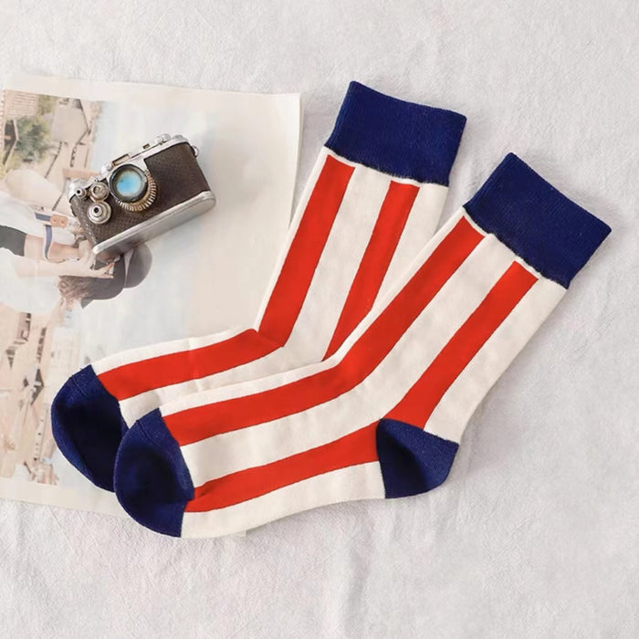 Angled view of Red and white striped crew socks with navy blue cuffs, heels, and toes.