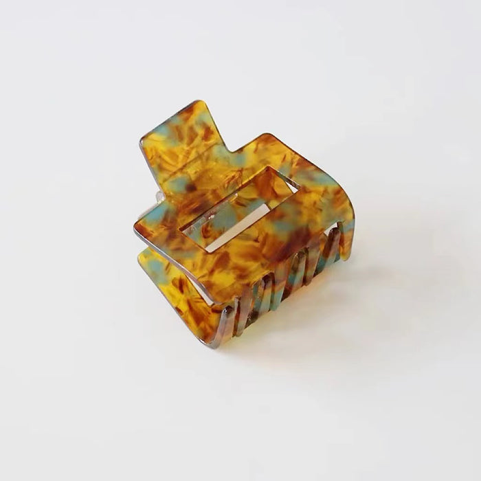 Angled view of Retro Hair Claw in cube shape, ideal for quick updos and ponytails.