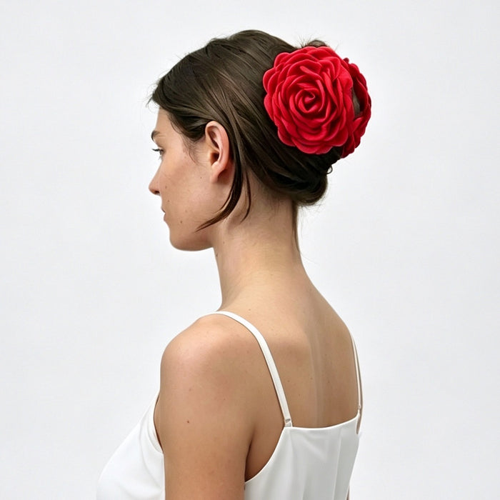 Side profile of a model wearing a bold red fabric rose hair claw clip.