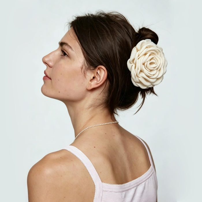 Sideview of a model showing a beige rose hair claw clip holding hair up.