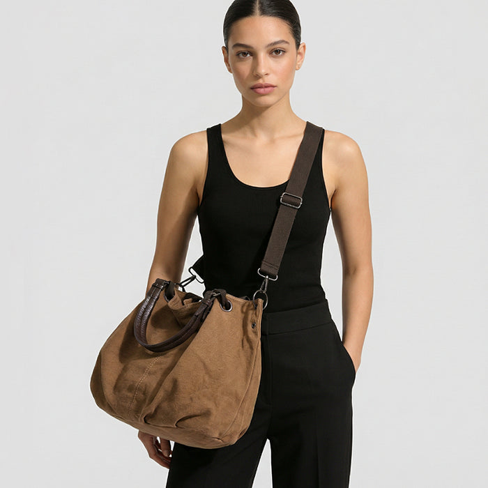 Model carrying the brown canvas tote bag crossbody style.