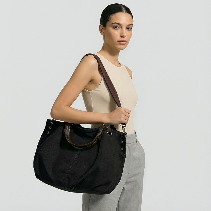 Model carrying the black canvas tote bag  as shoulder style.
