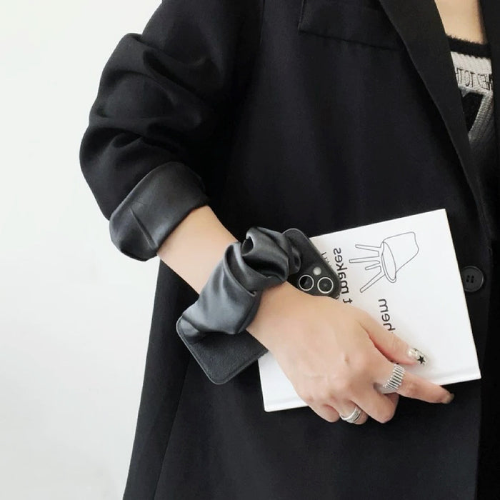 Front view of Black Satin Wristband Case. Integrated luxurious satin-textured strap for secure carry.
