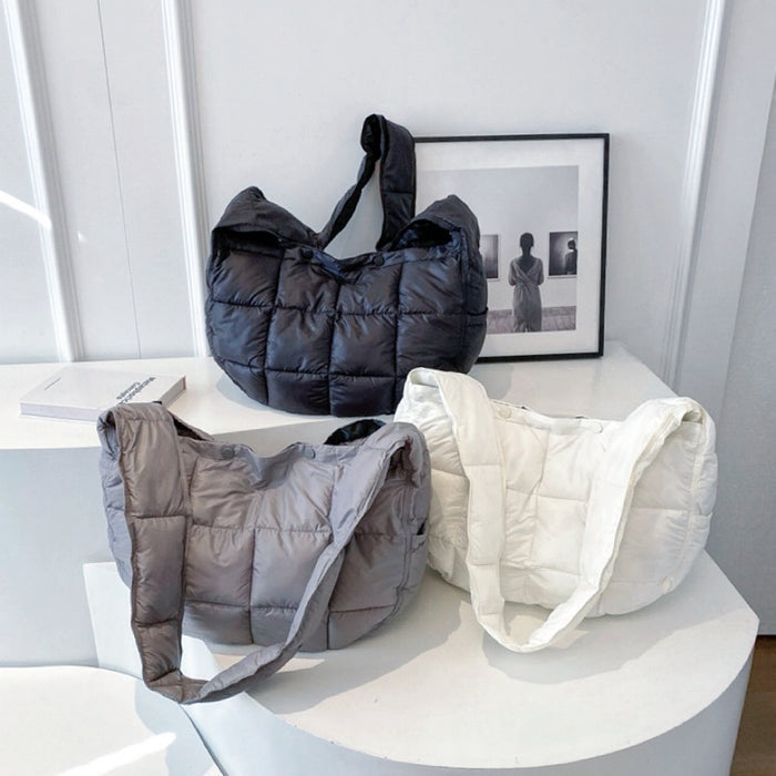 Three semicircle padded bags in black, grey, and white shown together.