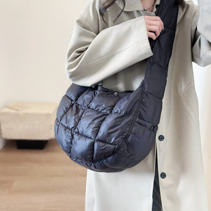 Side profile of black padded sling bag on a model; showcases the ergonomic semicircle fit.