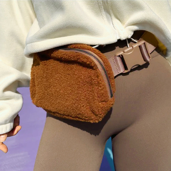 Model wearing the tan sherpa belt bag; cozy fleece fanny pack for winter athleisure.