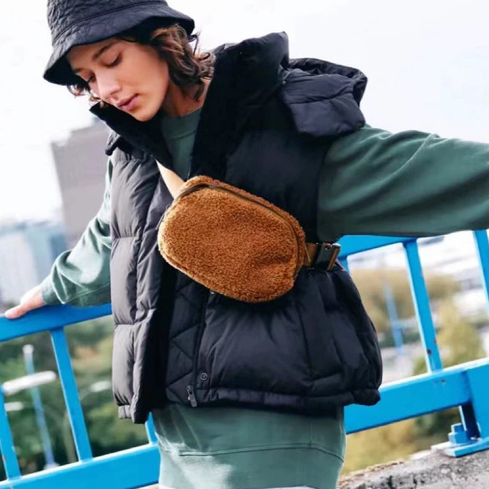 Model styling a tan sherpa belt bag as crossbody .