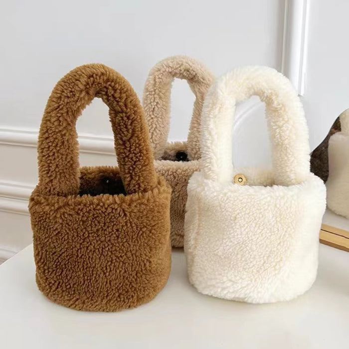 Front view of Three fluffy polyester Sherpa bucket handbags in brown, beige, and white, with short top handles.