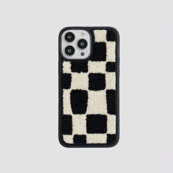 Black and white sherpa checkered phone case with a black silicone frame. Soft textured design.
