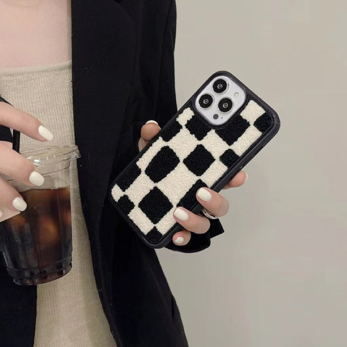 Model holding classic black and white checkered phone case in a soft, plush sherpa material.