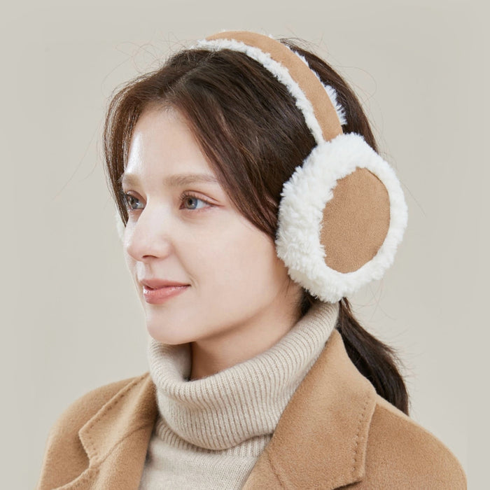 Model wearing brown sherpa polyester earmuffs with white trim, great for winter looks and travel days.