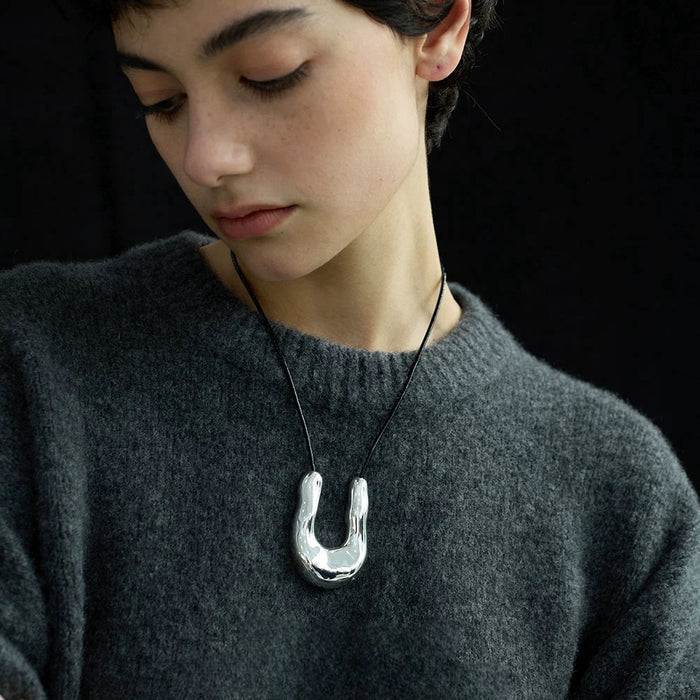 Model wearing a Crescent Pendant Necklace in Silver, easy to style for workdays.