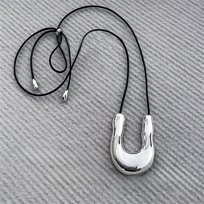 Flat lay of Silver Crescent Pendant Necklace, great for everyday outfits.
