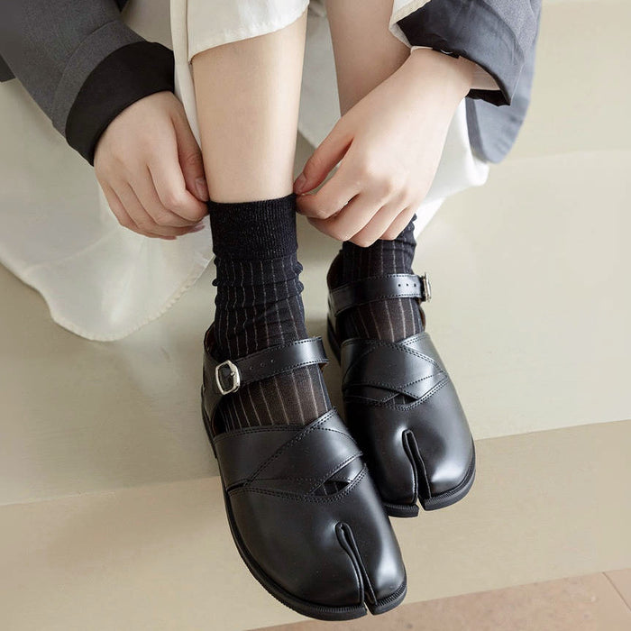 Model wearing a pair of black striped split-toe socks in crew length, great for casual wear and light workouts.