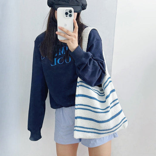 Model carrying a blue Simple Striped Knitted Bag on her shoulder, great for daily carry and travel.
