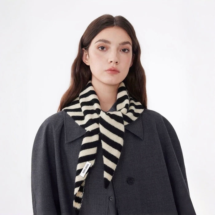 Model wearing a black and cream striped 100% wool triangular scarf, ideal for daily outfit.