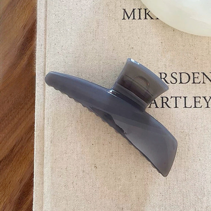 Angled view of Sleek Curved Hair Clawin gray, great for everyday styling and gifting.