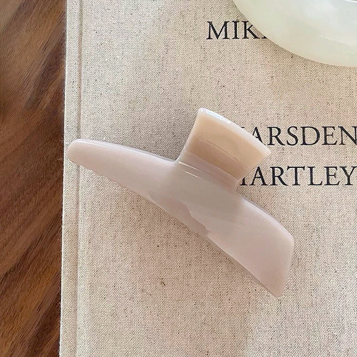 Close-up of Sleek Curved Hair Claw  in beige, ideal for quick updos and ponytails.