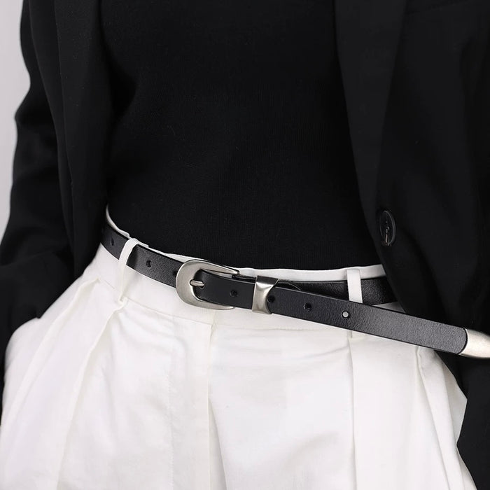 Minimalist leather belt styled with white formal high-waisted trousers.