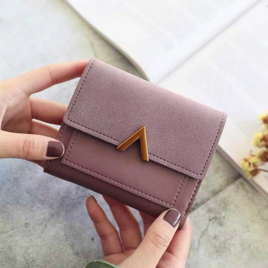 Model holding Small Wallet With Nubuck Leather Flap in pink, great for daily carry and travel.