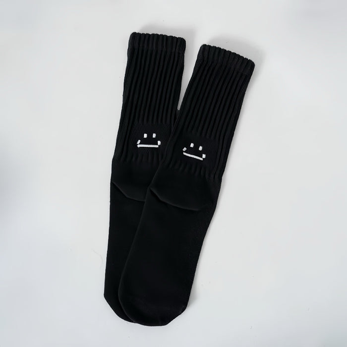 Front view of Smile Slouch Socks in black, easy to pack for travel and errands.