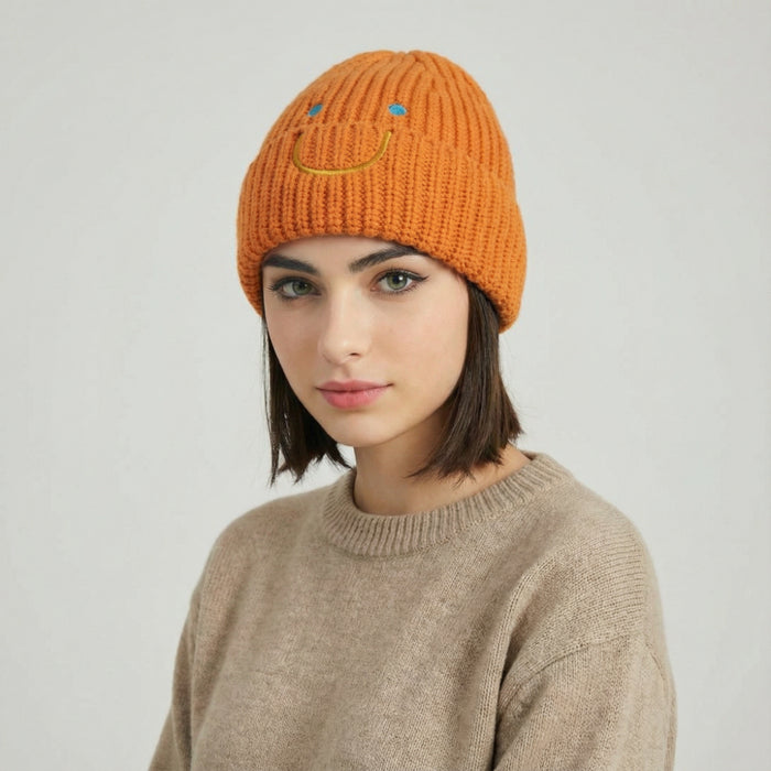 Model wearing Smiley Ribbed Knit Beanie in orange. Warm and soft ribbed knit for cold-weather comfort.