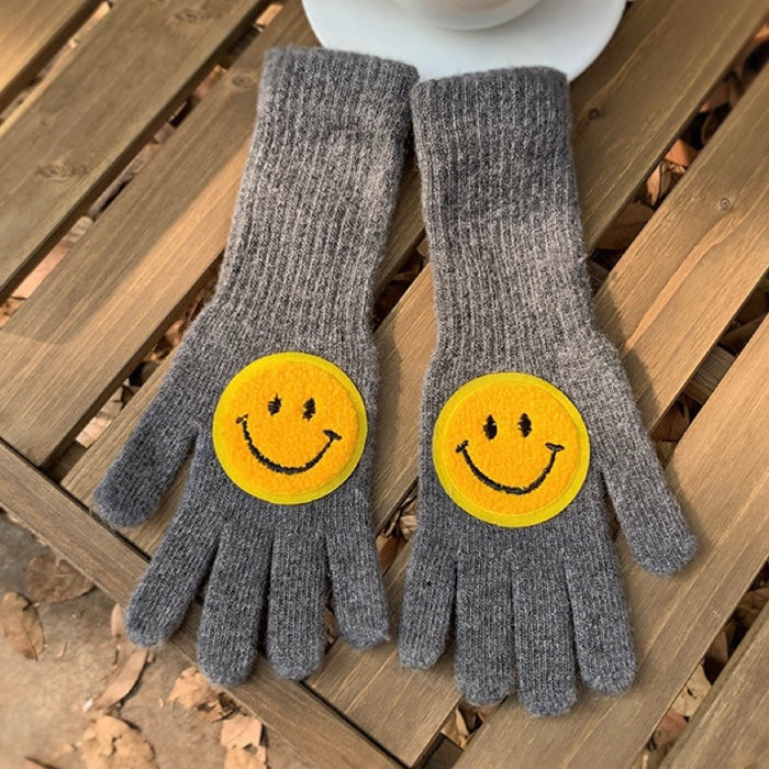 Grey smiling round face gloves with plush knit and smile patch; warm accessory for chilly weather.
