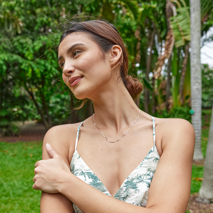 Woman in a tropical garden wearing 1.0mm Snake Chain in Sterling Silver