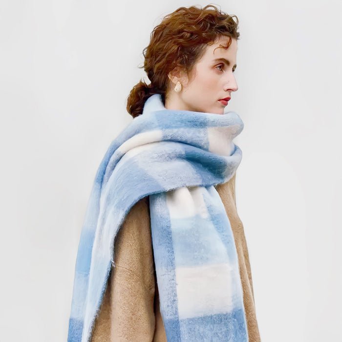 Model wearing soft cloud gradient plaid scarf in blue and white, made from polyester-acrylic blend in teal.